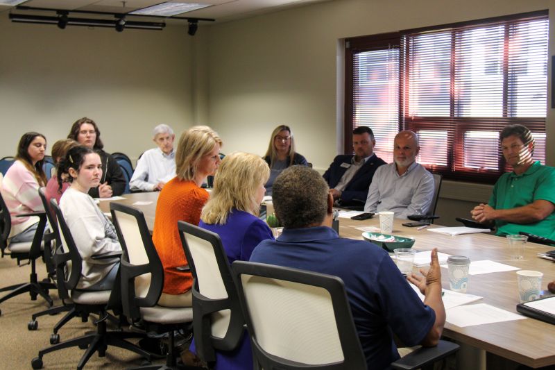 multiple people sitting around a table.