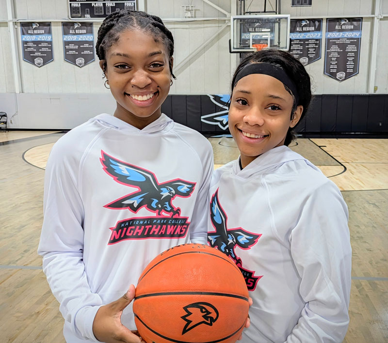 Kishaliya Doss and Ta'Keyla Williamson holding a basketball in the NPC gym.