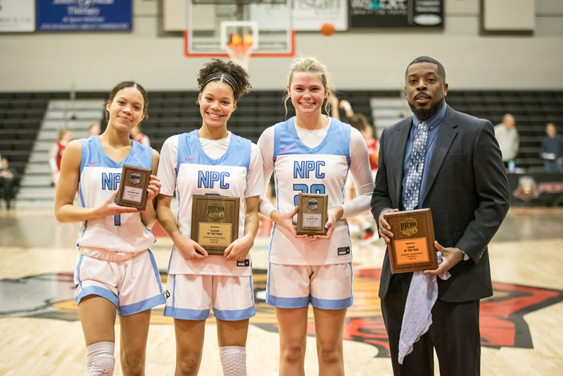 NPC women's all region basketball players with their coach. 