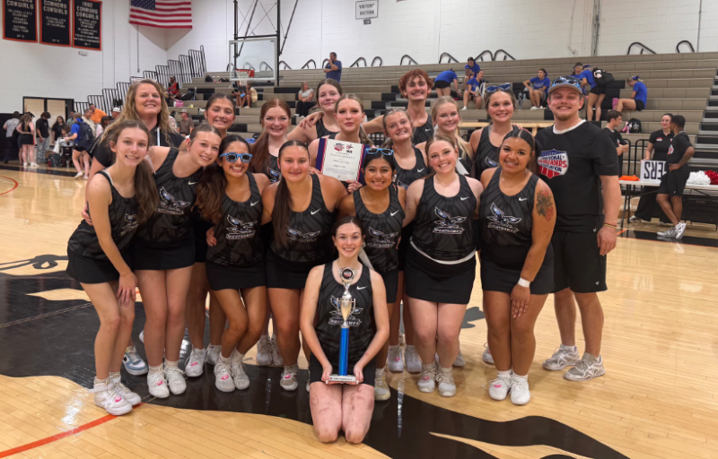 Cheer team group photo holding trophy.