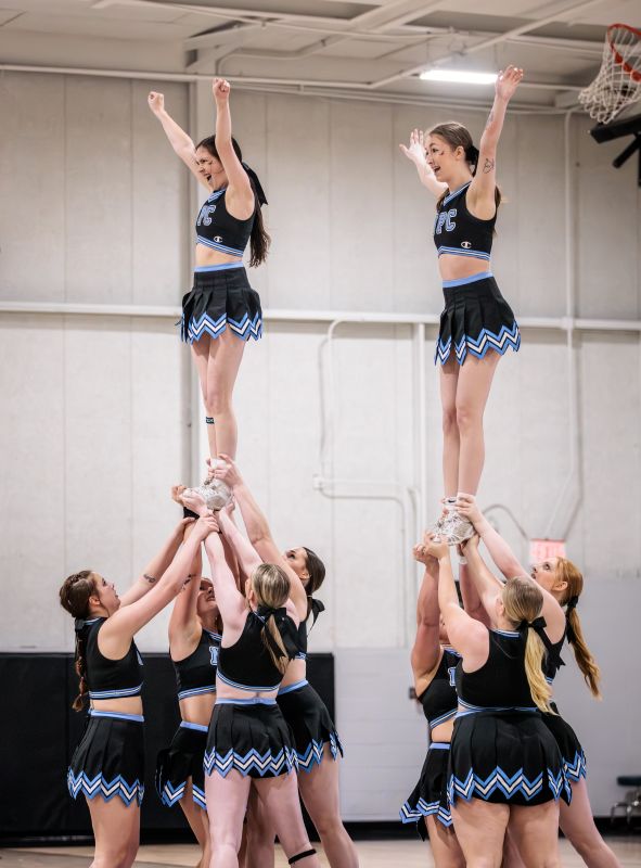 Cheerleaders doing two pyramid stunts.