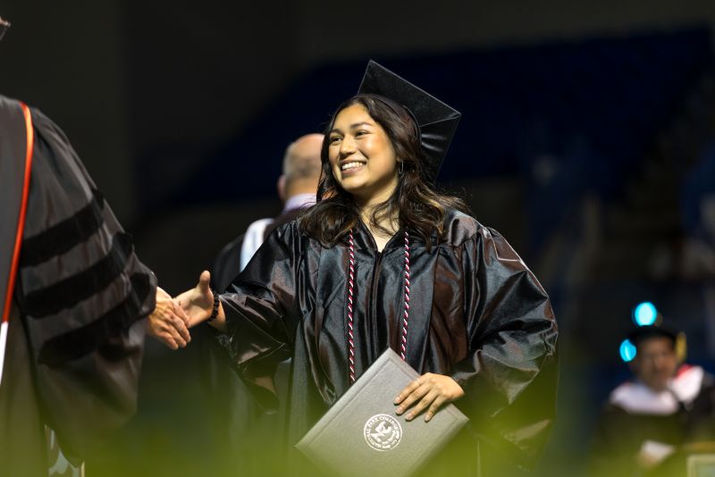 Person walking across graduation stage.