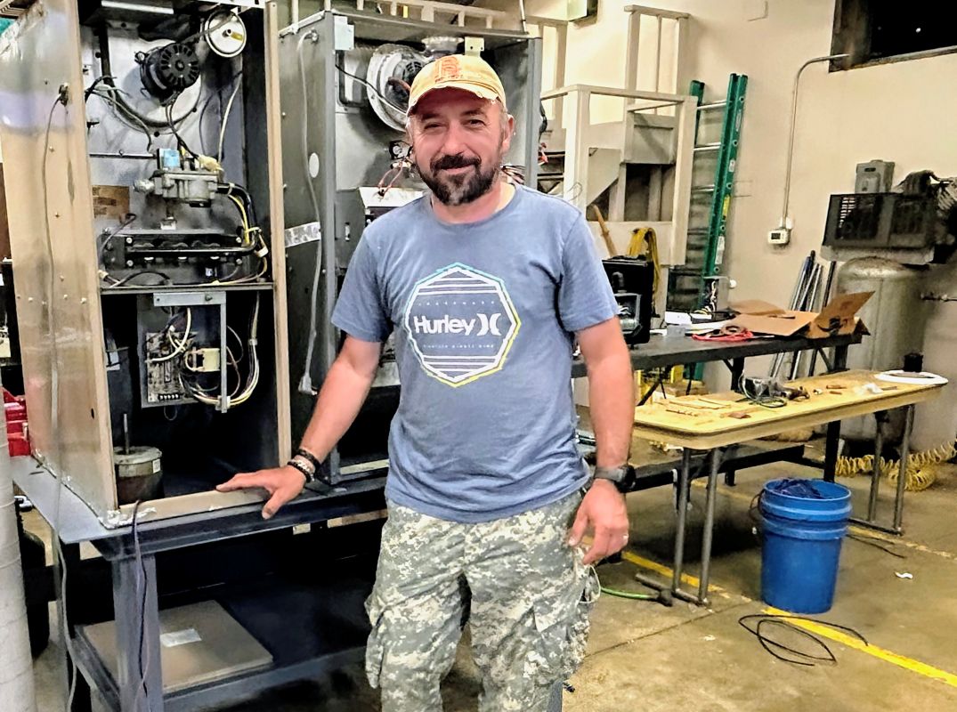 Ioan Ardelean stands in front of HVAC equipment.