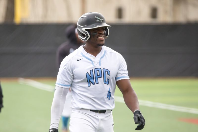Demias Jimerson smiling in his baseball uniform on the field.
