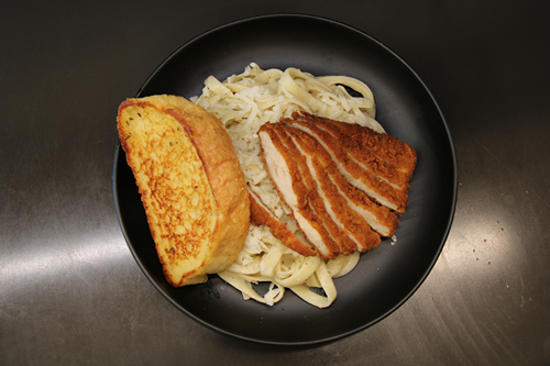 Pasta with fried chicken breast and garlic bread