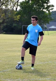 NPC soccer player with foot on soccer ball.