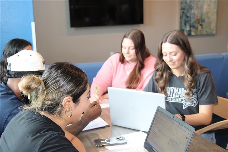 Students working on computers in a community space